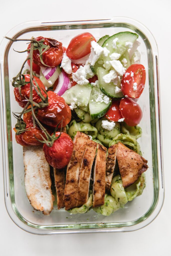 Lunch box-pesto pasta, marinated chicken with greek salad and baked tomatoes